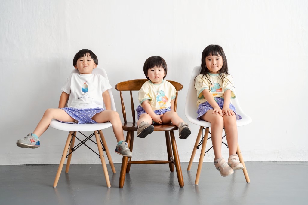 3人兄弟がイスに座ってならぶ