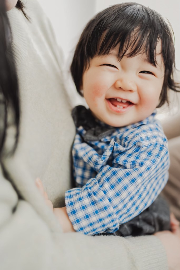 ママに抱かれて満面の笑みの赤ちゃん