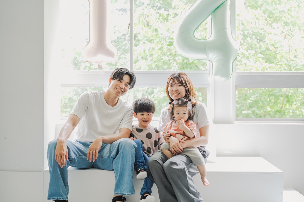 窓辺で笑う家族4人