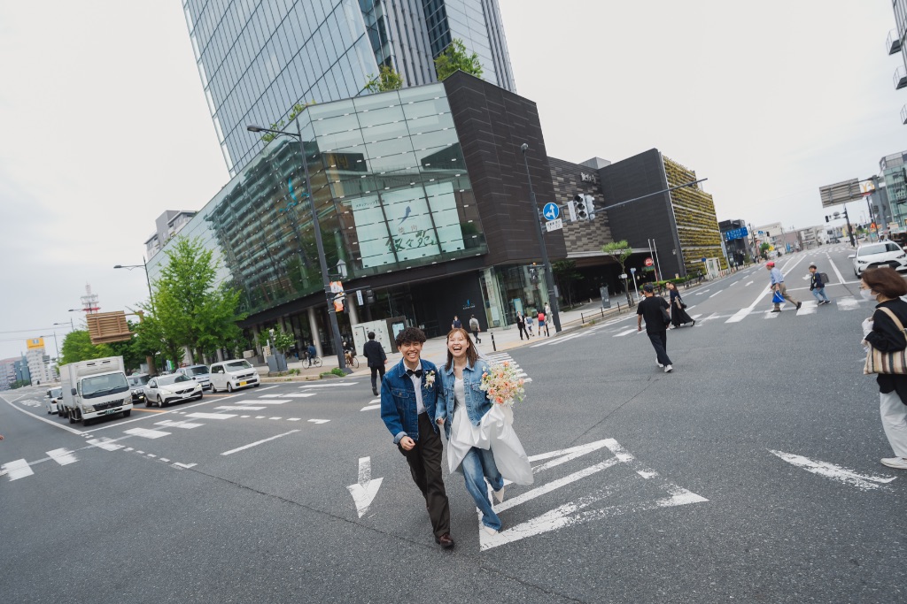 賑やかな市街地の交差点を渡るカップル
