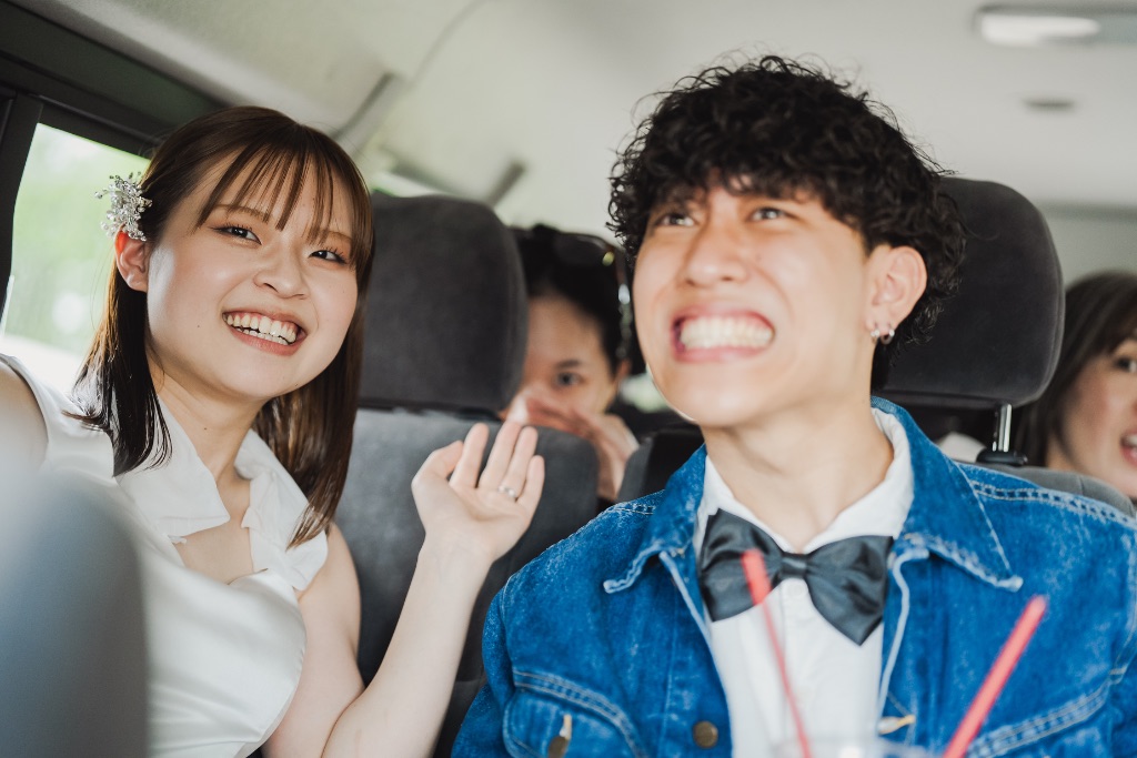 車の中で笑顔のカップルと友人たち