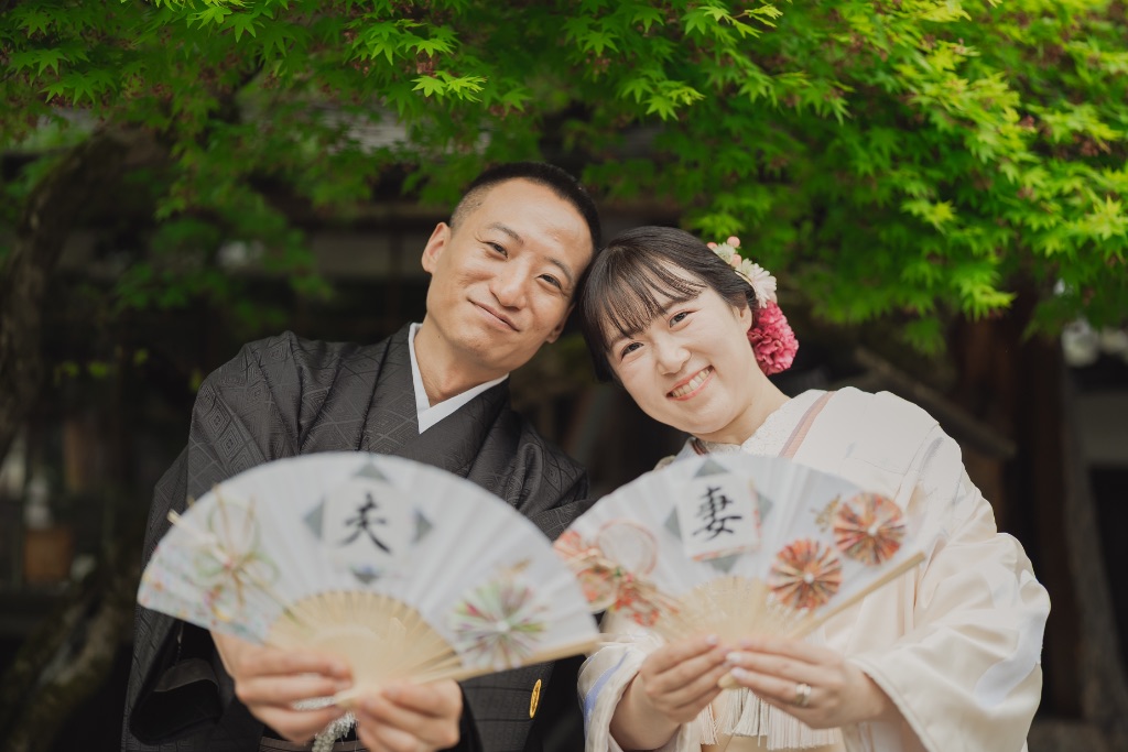 夫・妻と書かれた扇子を持つ着物カップル