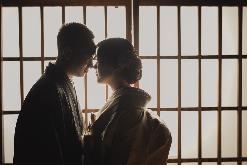 障子越しにシルエットで向き合う着物カップル